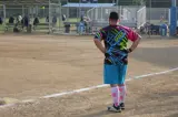 man standing on softball field wearing colorful neon clothing