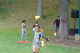 woman spinning flaming batons