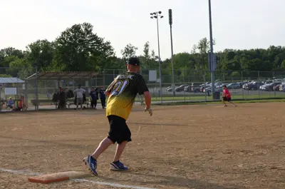 person running off of first base while playing softball