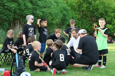 youth soccer players huddled around coach