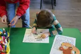 young boy coloring with markers