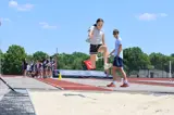 young girl jumping into sand in long jump event
