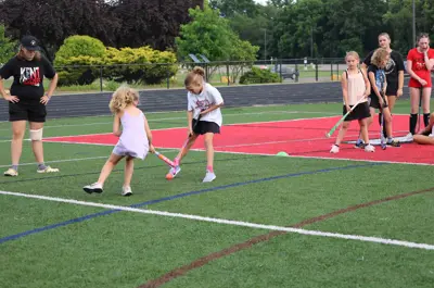 two girls playing field hockey