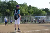 man standing on third base during a softball game