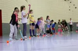 Field hockey players standing in a line on the side of the indoor court