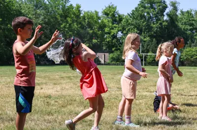 Young campers catching water balloons