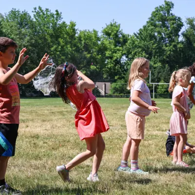 Young campers catching water balloons