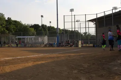 the sun setting on a softball field