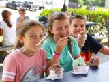 Three kids smiling while eating ice cream