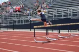 young girl jumping over a hurdle