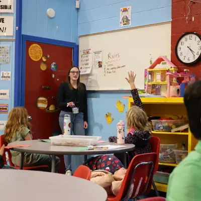 child raising their hand to ask a question to a counselor 