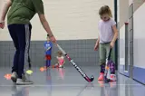 young girl and mentor holding field hockey sticks